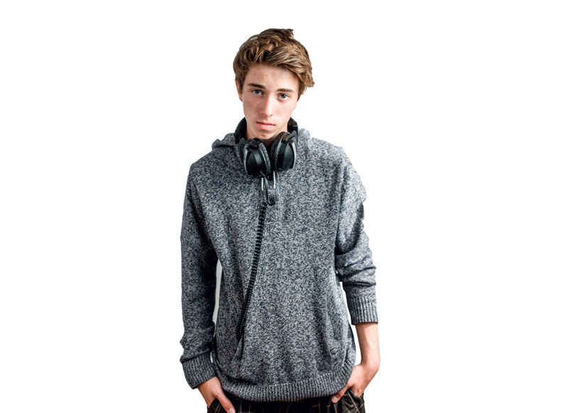 Antonas stovi rankas įsikišęs į kišenes. Vilki pilką džemperį su gobtuvu, ant kaklo yra užsidėjęs dideles juodas ausines. Jo veido išraiška rimta, galva šiek tiek palenkta, žiūri tiesiai. Fonas baltas.